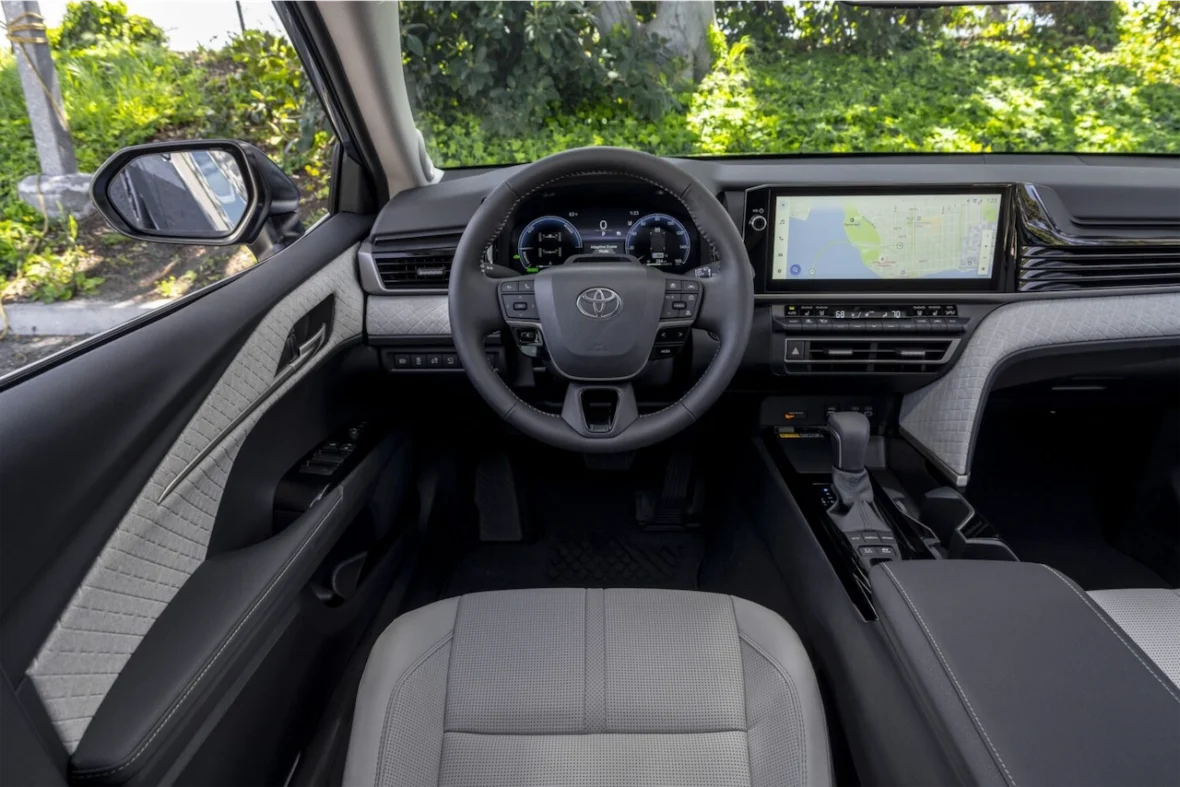 Interior view of a modern car showcasing the steering wheel, dashboard, and infotainment screen with navigation map.