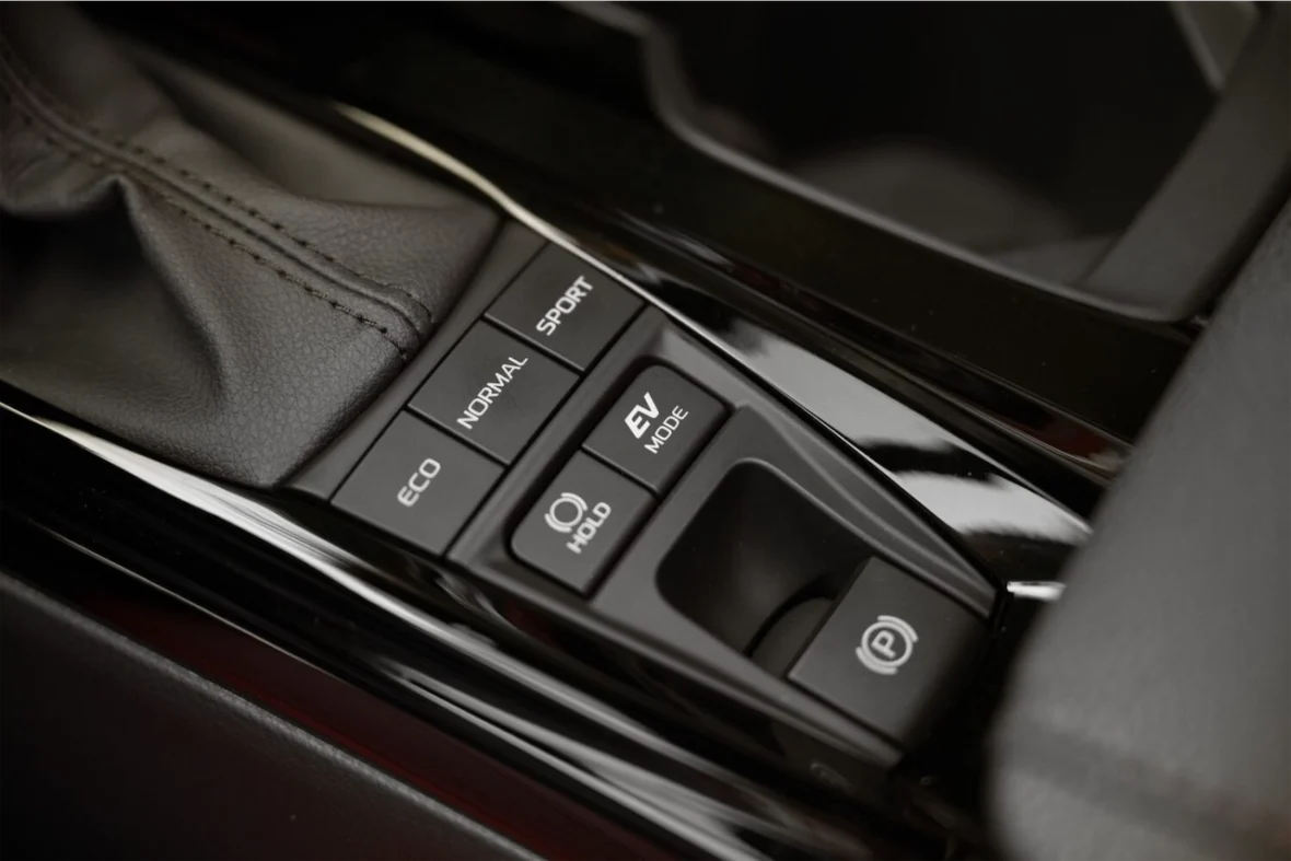Close-up view of a car's center console featuring drive mode buttons labeled ECO, NORMAL, SPORT, EV MODE, and a parking brake button.