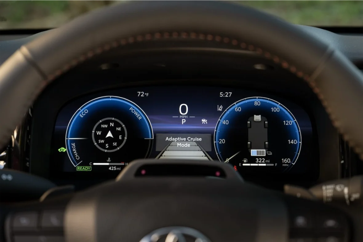 Close-up view of a car's digital dashboard displaying speed, fuel range, temperature, and activation of adaptive cruise mode.