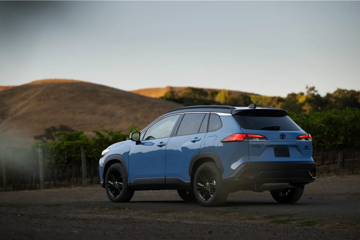 Rear view of the Corolla Cross Hybrid XSE in Cavalry Blue on a hillside