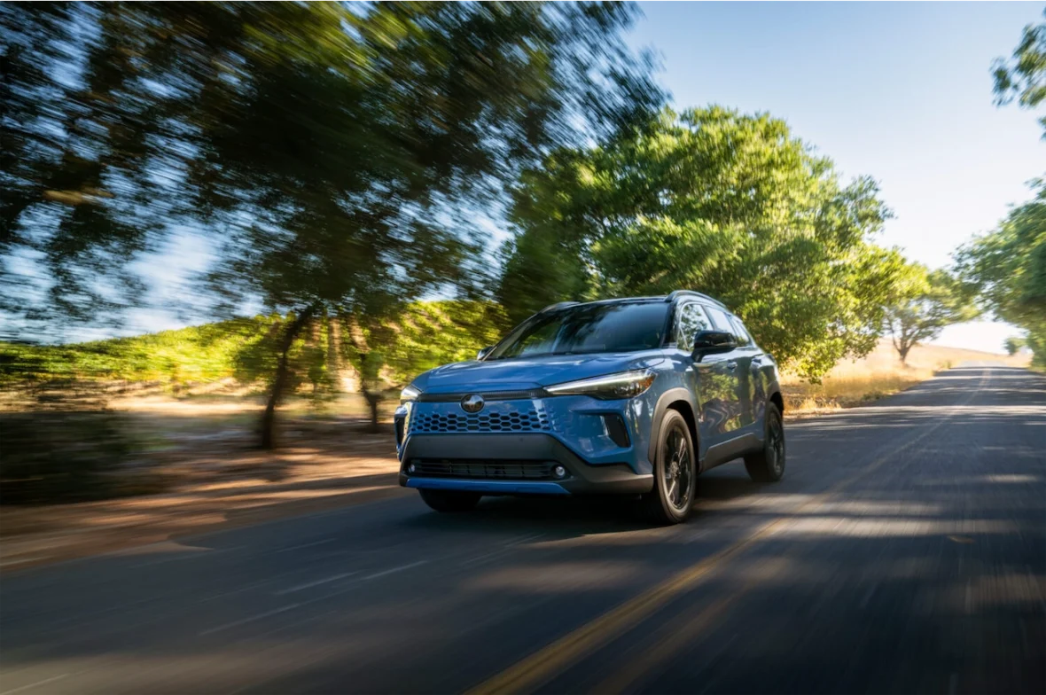 Corolla Cross Hybrid XSE driving under oak trees