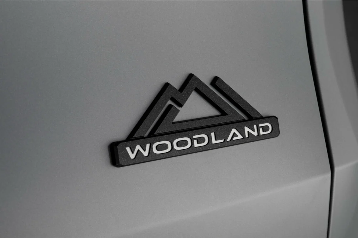 Black Woodland badge with a mountain logo on the Grand Highlander