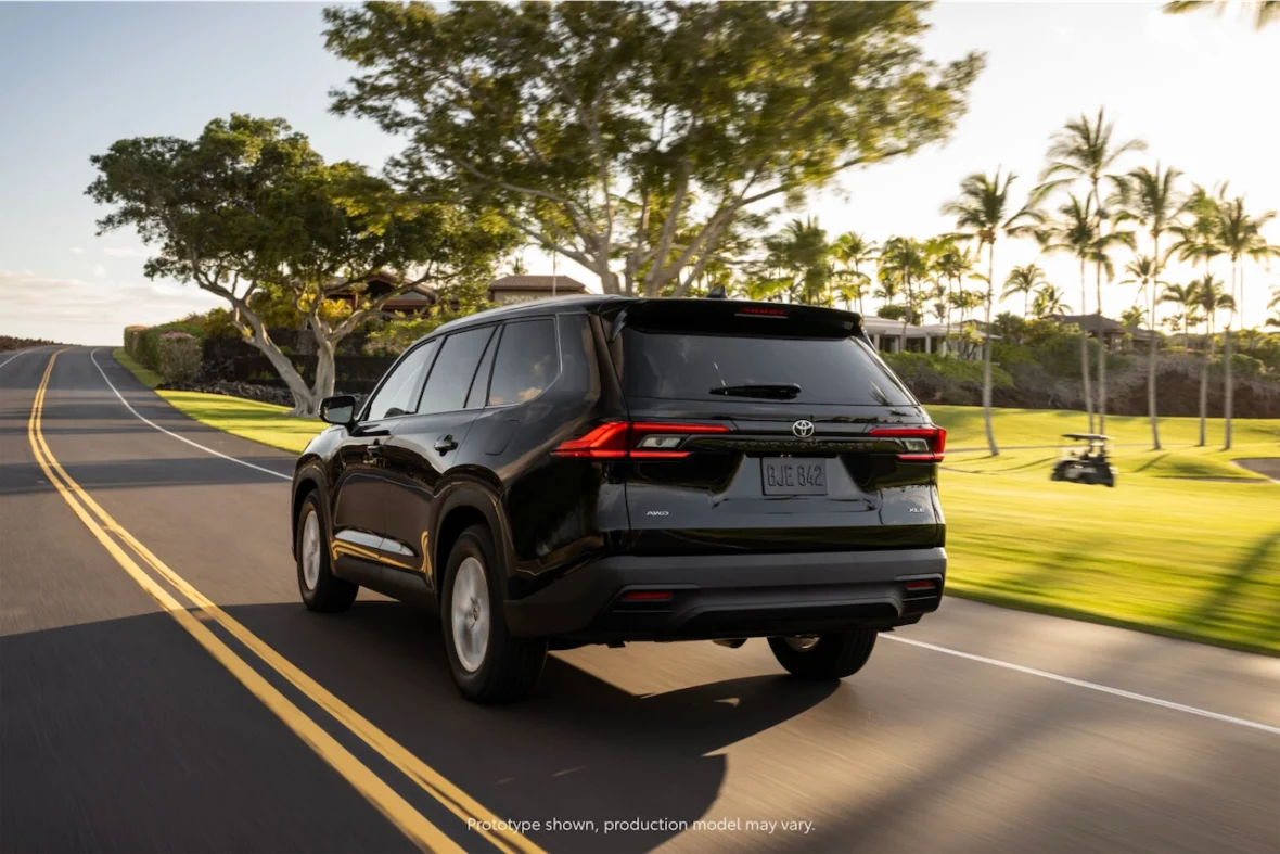 Rear view of a 2027 Grand Highlander XLE in Blueprint on an open road