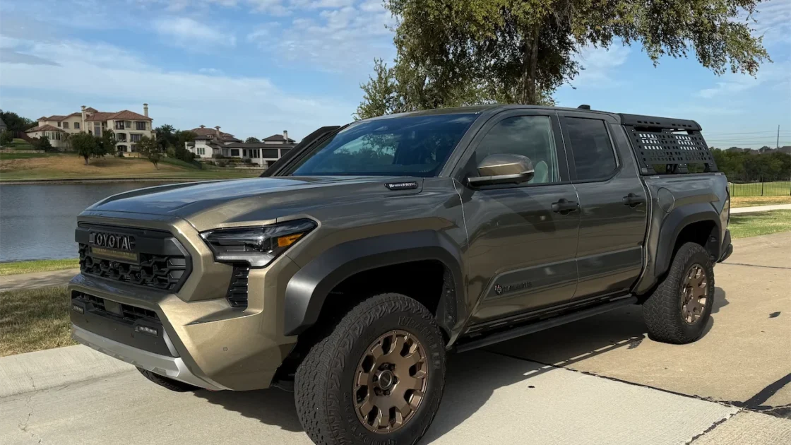 2026 Toyota Tacoma Trailhunter in Bronze Oxide with bronze wheels, parked by a lake.