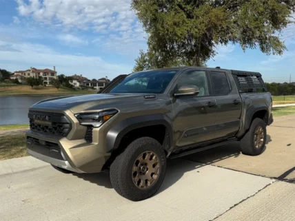2026 Toyota Tacoma Trailhunter in Bronze Oxide with bronze wheels, parked by a lake.