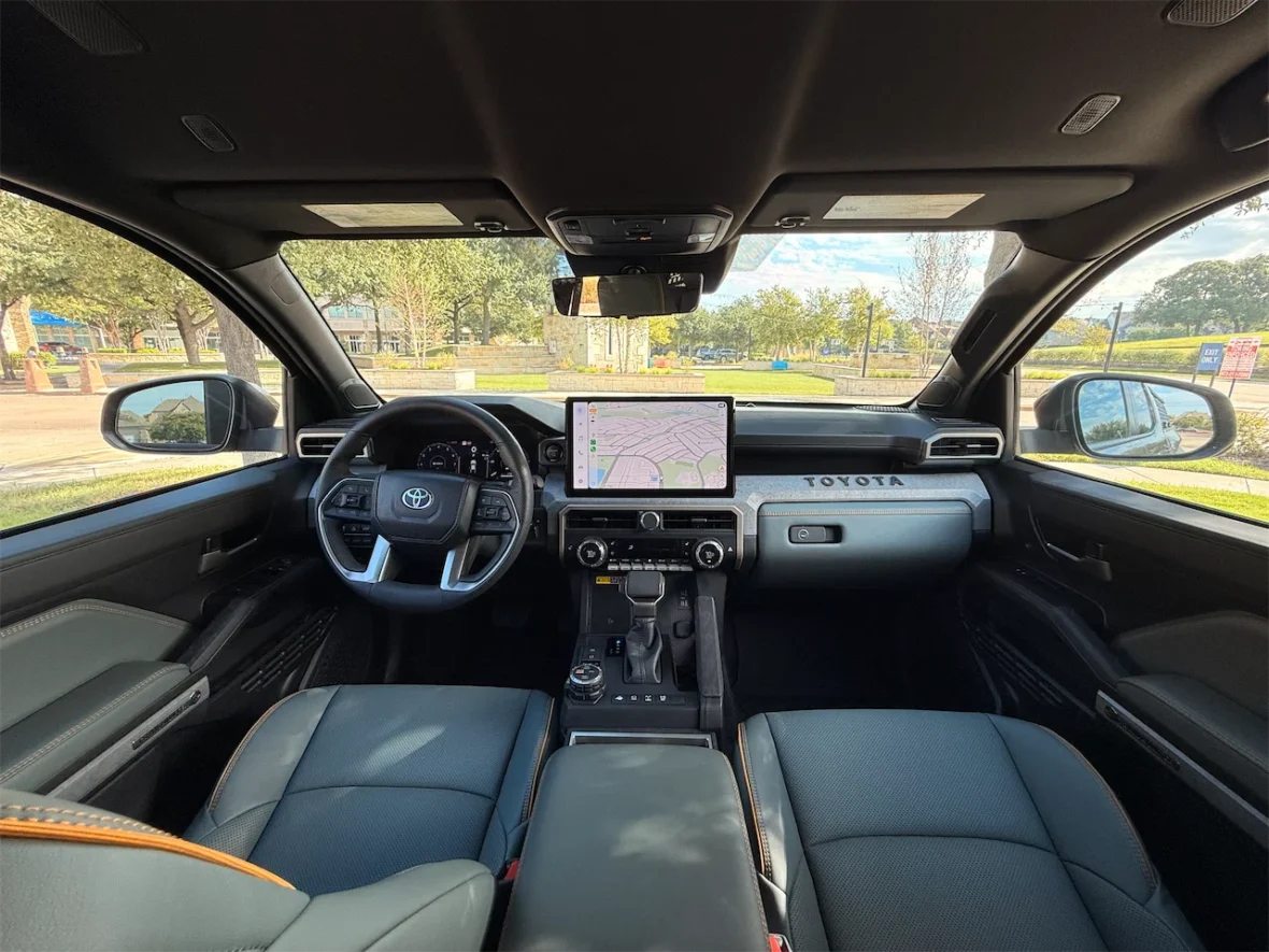 Interior view of a modern Toyota vehicle showcasing a sleek dashboard, steering wheel, and a large touchscreen display with navigation options.
