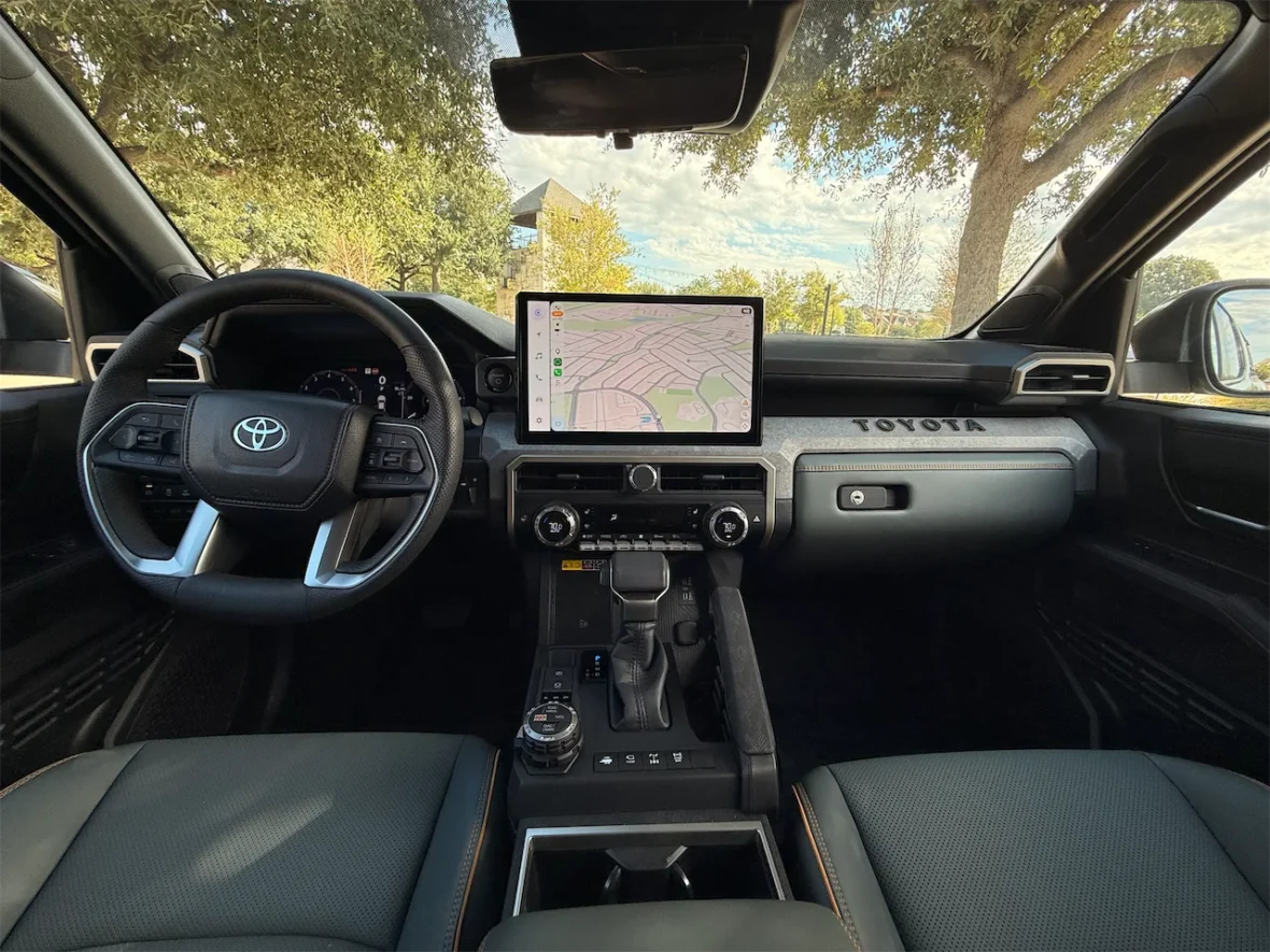 Interior view of a Toyota vehicle featuring a modern dashboard, steering wheel, and a large touchscreen display with a map interface.