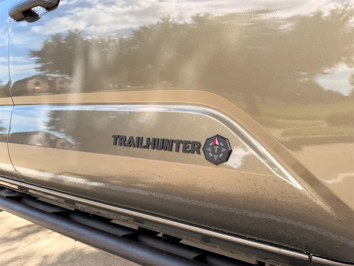 Close-up of a vehicle's side featuring the 'TRAILHUNTER' logo and emblem.