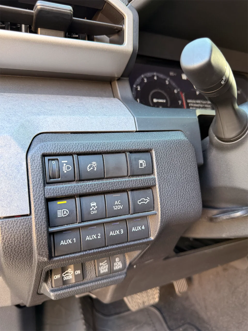 Dashboard switch bank in the Tacoma Trailhunter, including AUX 1 through AUX 4 accessory switches.