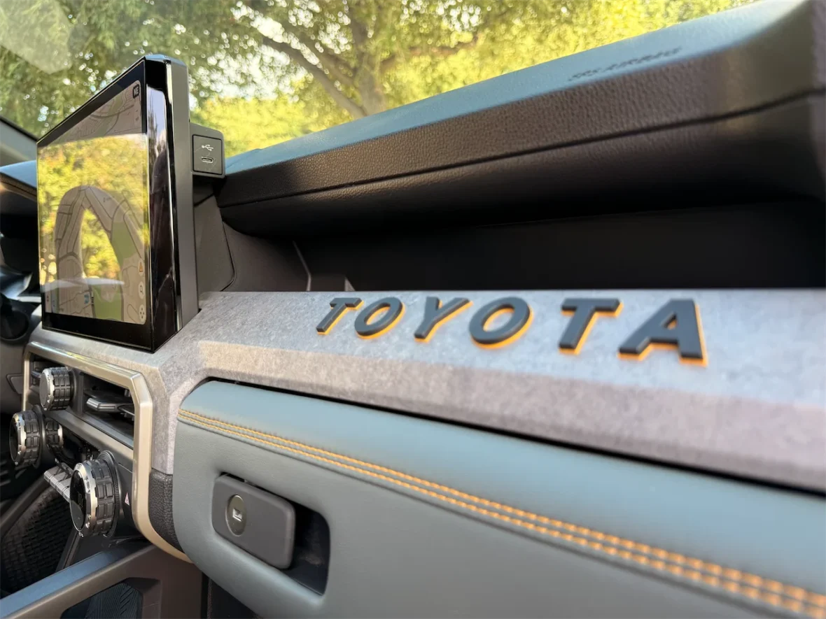 Close-up view of a car's dashboard featuring a touchscreen display and the Toyota logo.