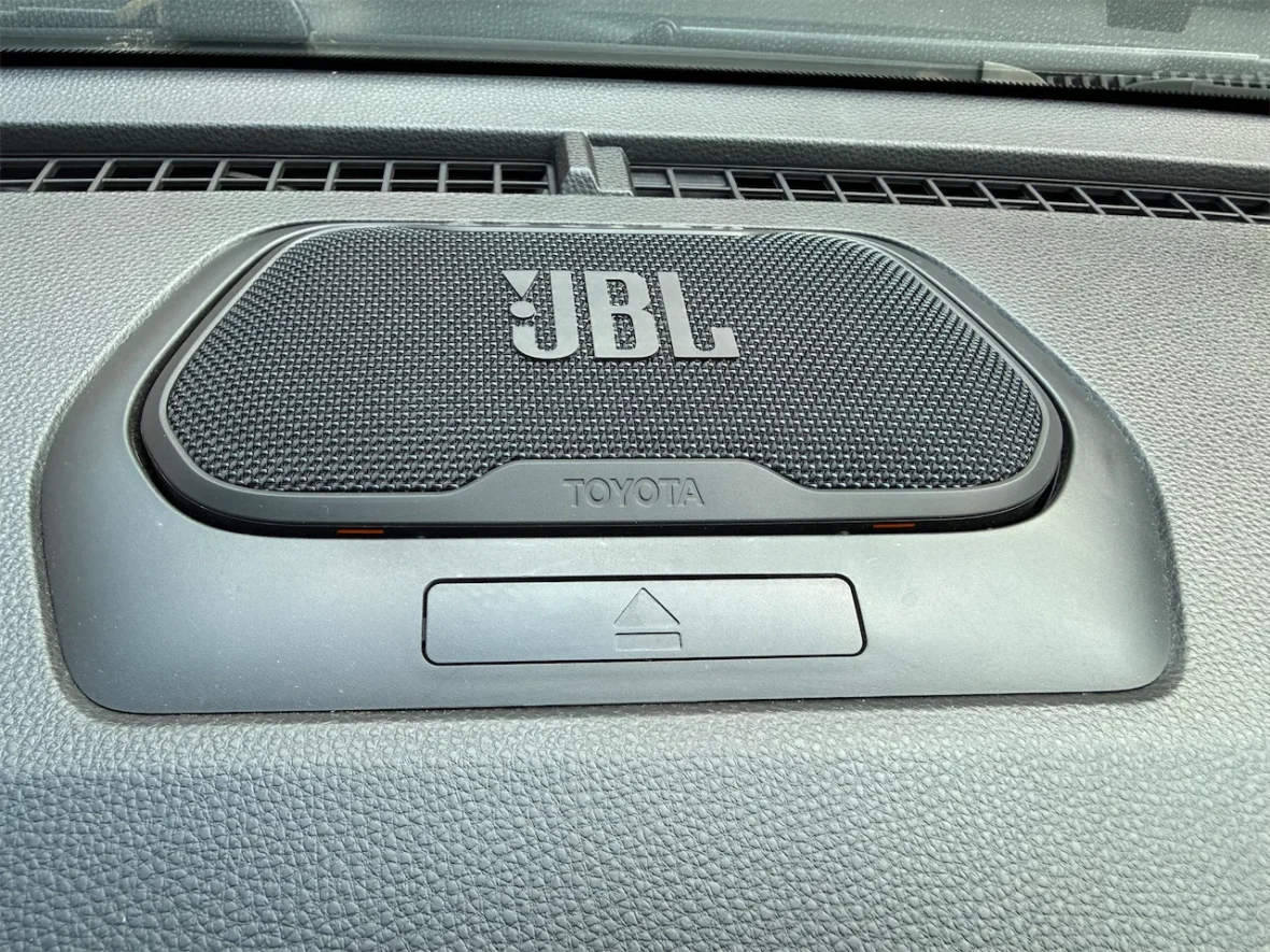 A close-up of a JBL car speaker integrated into a Toyota dashboard.