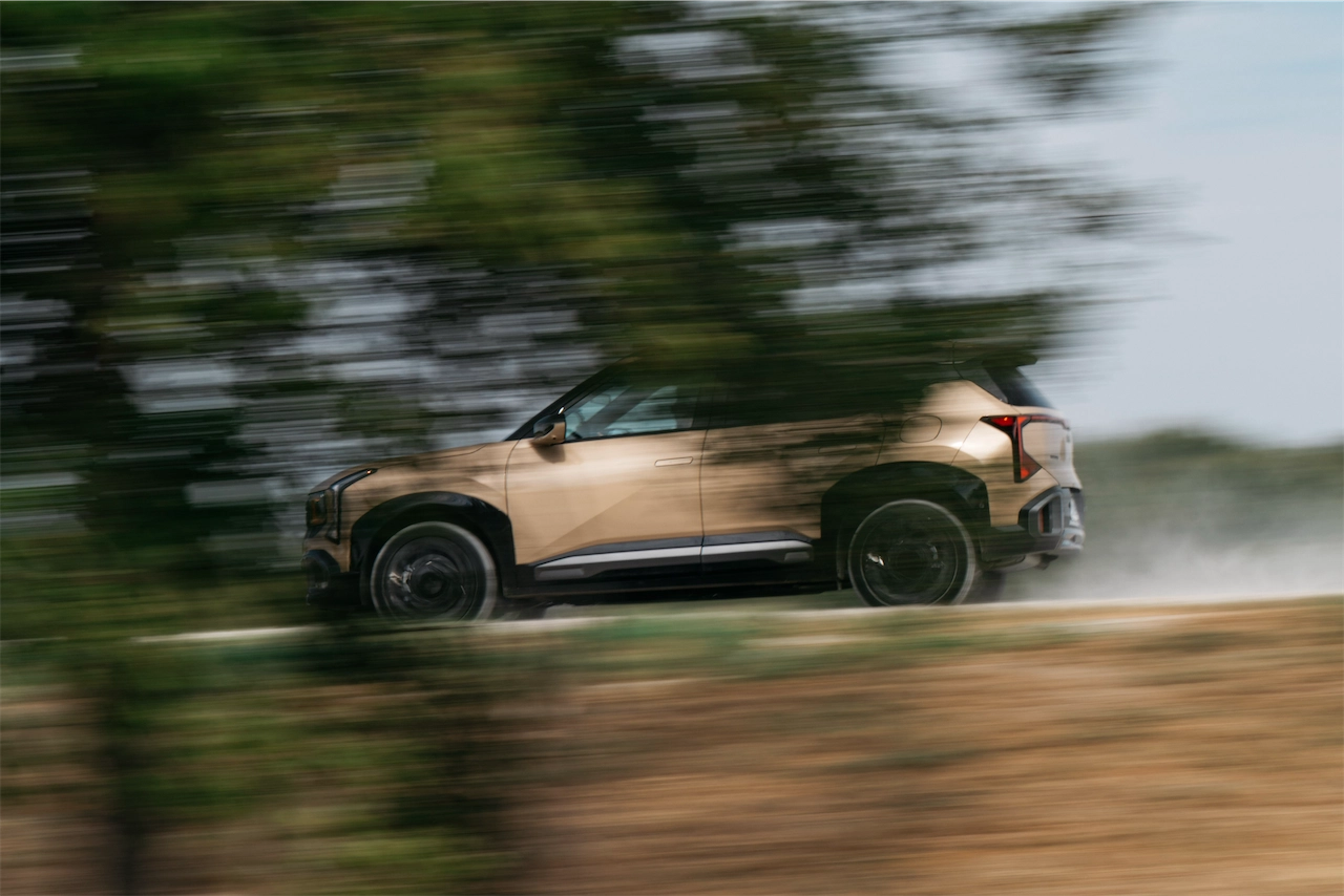 2027 Kia Seltos X-Line SX AWD driving past trees on a rally course