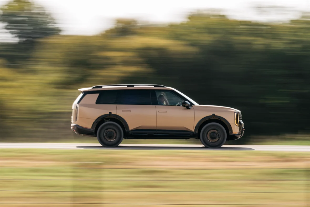 A beige SUV in motion on a road with blurred background, suggesting speed.