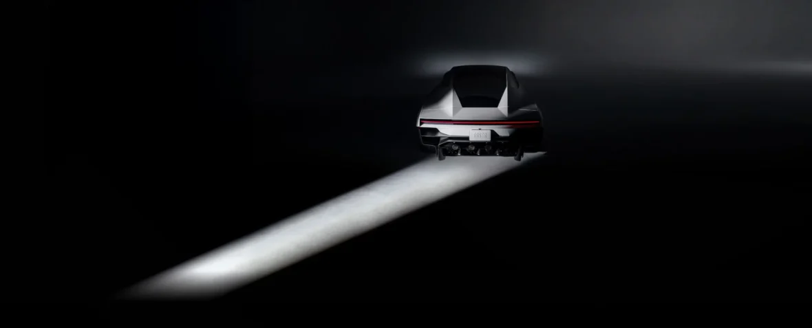New Tesla Roadster in a dark studio with its headlights on