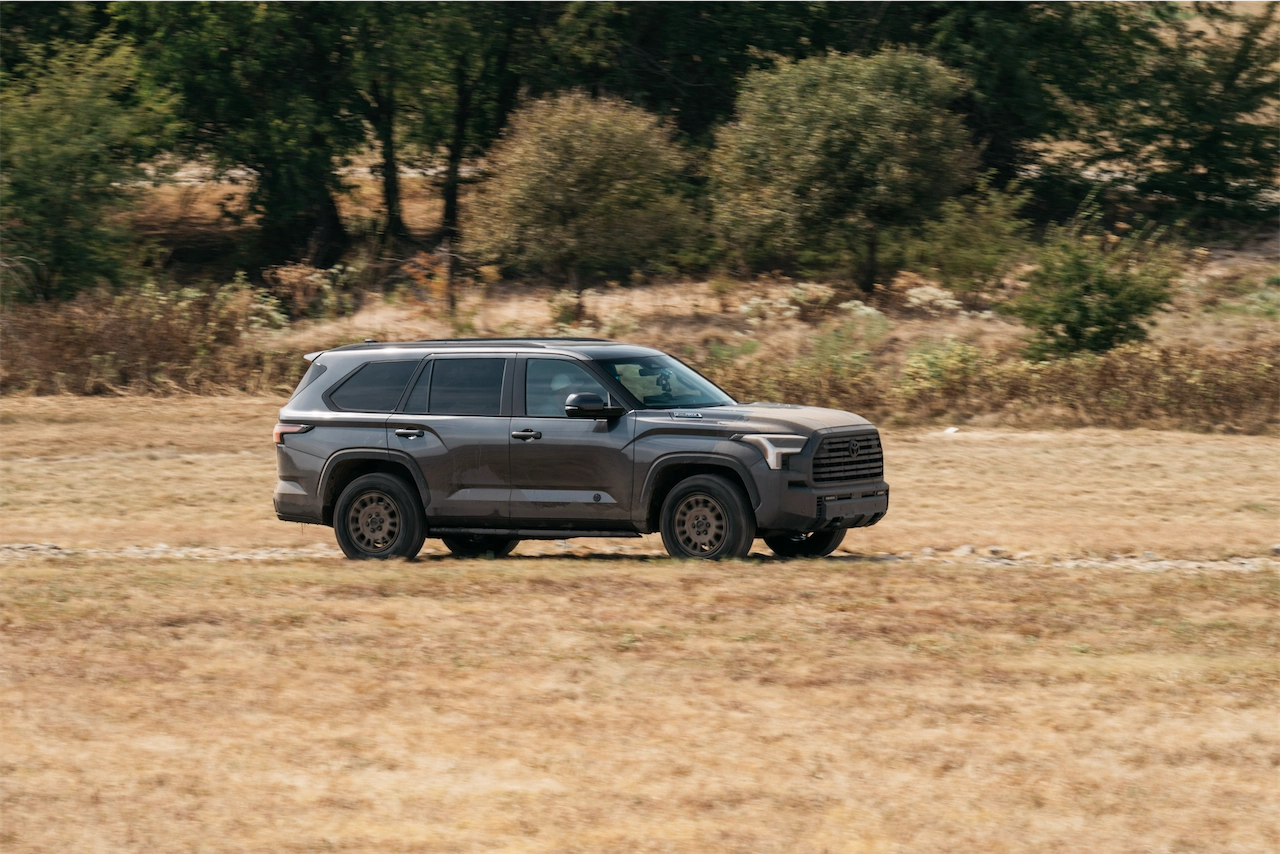 Gray SUV with bronze wheels parked in a dry Texas field