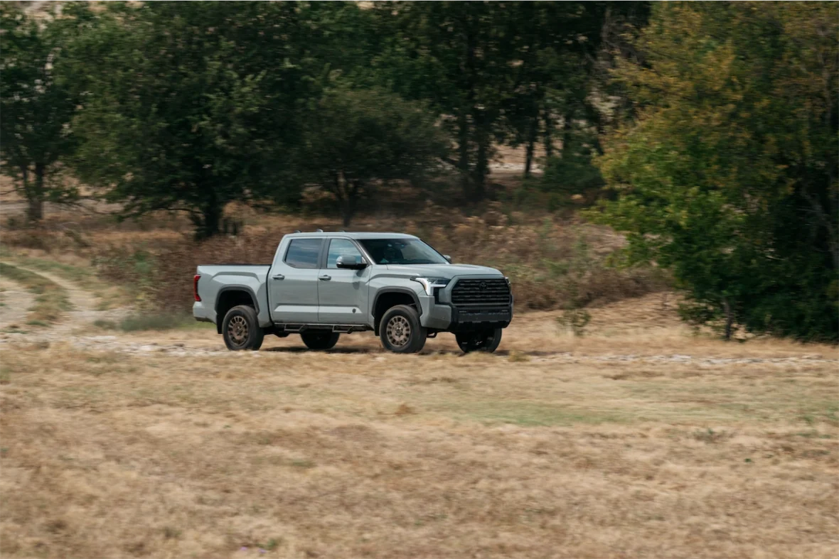 2027 Toyota Tundra Trailhunter four-door cab driving across a grassy field