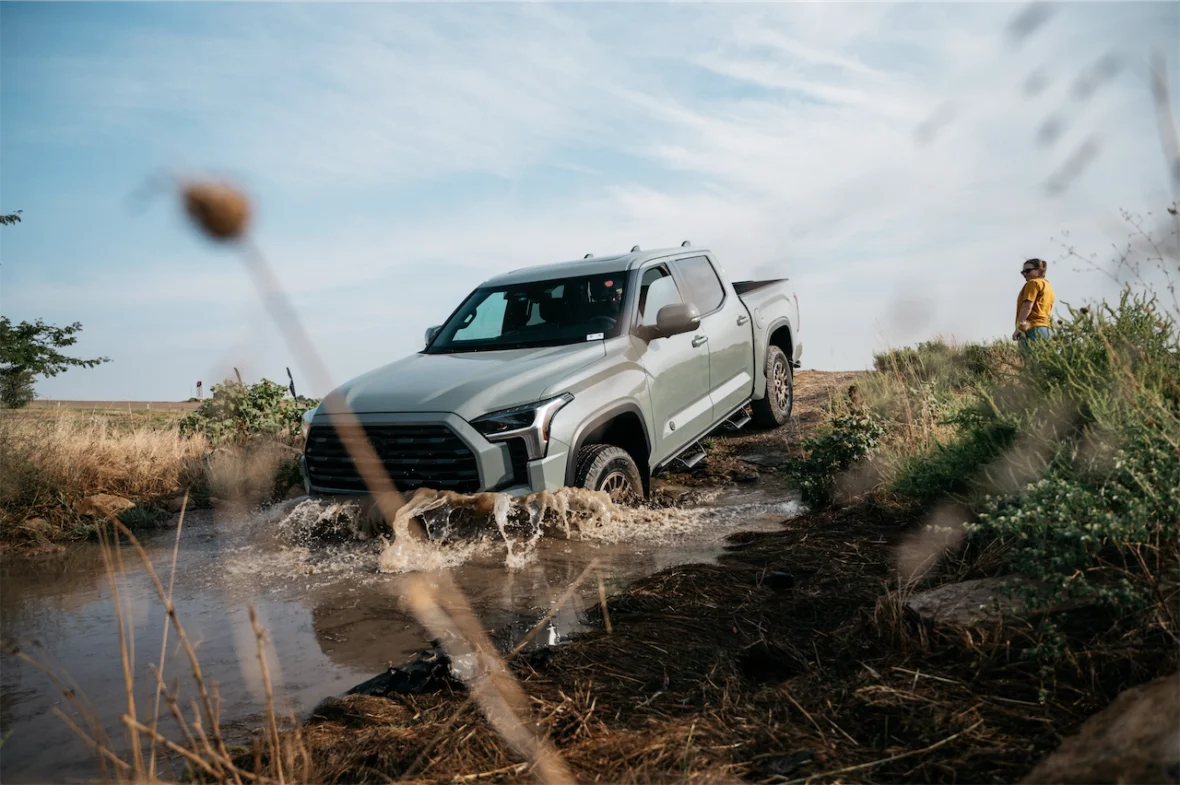 2027 Toyota Tundra Trailhunter splashing through a muddy water crossing
