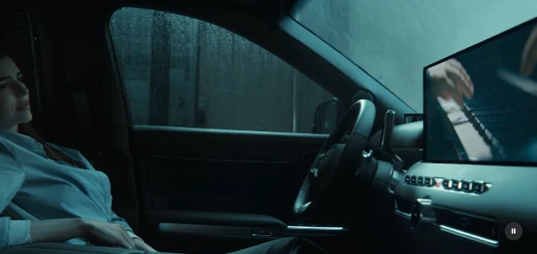 Passenger watching a concert on the Genesis GV90 Cinematic Display